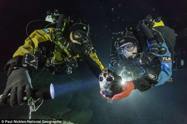 潜水员阿尔贝托-纳瓦和苏珊-伯德正在运送这个头骨到一个水下转盘，目的是拍摄获得头骨3D模型。